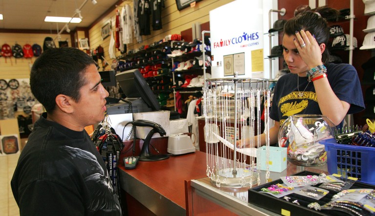 Cameron Hinojosa hands a store clerk his resume at the Family Clothes store in Fresno, Calif.