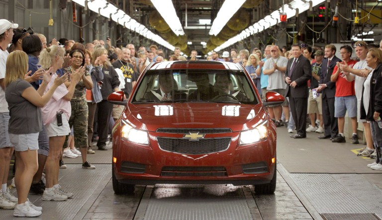 General Motors workers cheer at GM North America President Mark Reuss, right, with front seat passenger Ohio Gov. Ted Strickland, drives the first Chevrolet Cruze compact sedan off the assembly line, Wednesday, Sept. 8, 2010, at the GM factory in Lordstown, Ohio.
