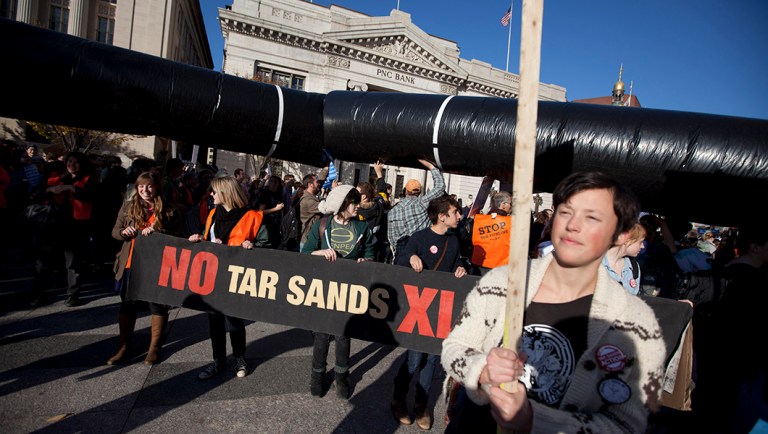 Demonstrators march with a replica of a pipeline during a protest to demand a stop to the Keystone XL tar sands oil pipeline.
