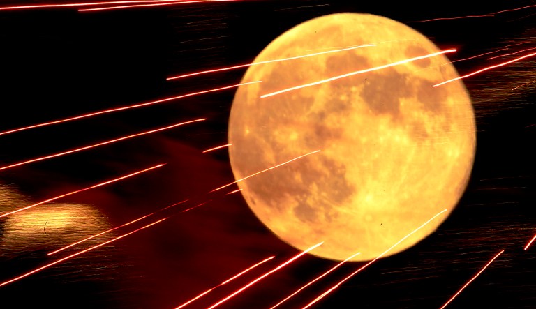 Fireworks light up the sky against a full moon during a Fourth of July celebration in Kansas City, Kan., in 2012.