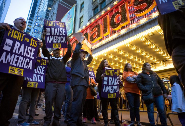 In this Wednesday, April 15, 2015, file photo, protestors pause near a McDonald's restaurant in Times Square during a rally and march in New York, as participants, fast food workers and union members call for a $15 minimum wage. 
