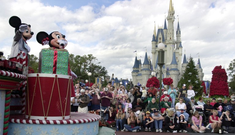 FILE - In this Dec. 22, 2004, file photo, visitors gather in front of Cinderella's Castle to watch Mickey and Minnie Mouse during the Christmas parade at Walt Disney World's Magic Kingdom in Lake Buena Vista, Fla. Disneyland, the original theme park, opened in 1955. Company founder Walt Disney oversaw its construction on a 65-hectare (160-acre) orange farm in what was then a semi-rural part of Orange County. The parkâs original four themed areas - Fantasyland, Frontierland, Adventureland and Tomorrowland - were later joined by Critter Country and New Orleans Square. A Star Wars-themed expansion is in the works.