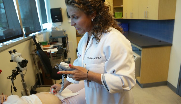 In this Tuesday, Aug. 2, 2016 file photo, nurse practitioner Juliana Duque uses a fetal heart monitor on a patient who is in her first trimester of pregnancy at the Borinquen Medical Center, in Miami. The CDC has advised pregnant women to avoid travel to the nearby neighborhood of Wynwood where mosquitoes are apparently transmitting Zika directly to humans. The patient also had a test for Zika following her exam.