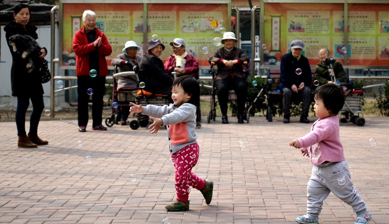 Children play bubbles at a residential compound in Beijing.