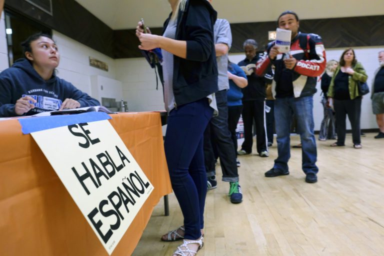 A sign that reads "Spanish is Spoken Here" hangs as voters check in at the North Hollywood Amelia Earhart Regional Library polling station in Los Angeles on Tuesday, Nov. 8, 2016.
