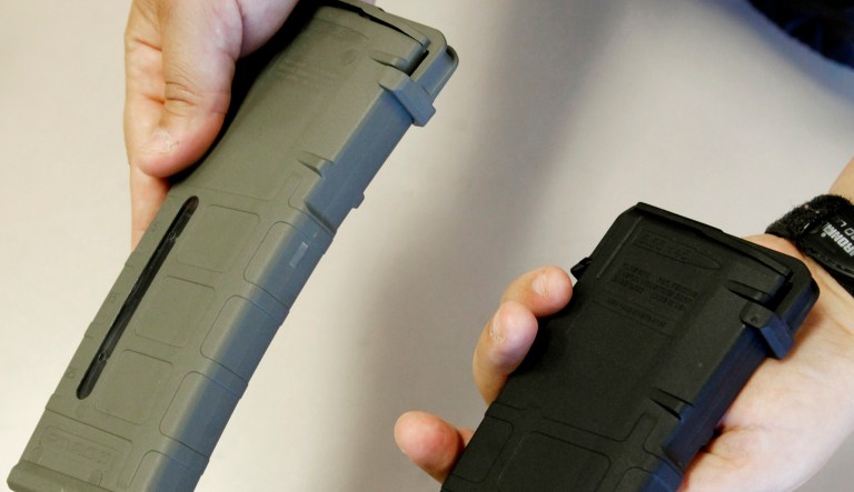 A pair of ammunition magazines, one that can hold 10 shots, right, and a 20-round magazine are displayed at TDS Guns in Rocklin, Calif.