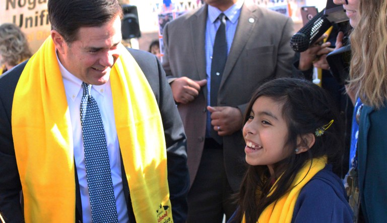 Arizona Gov. Doug Ducey talks with 11-year-old Lourdes Garza, a 6th grader at a school choice event at Pioneer Preparatory Academy charter school at the state Capitol, Thursday, Jan. 26, 2017, in Phoenix.