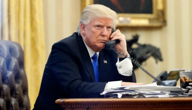 President Donald Trump speaks on the phone with Prime Minister of Australia Malcolm Turnbull in the Oval Office of the White House, Saturday, Jan. 28, 2017 in Washington.