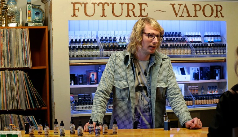 Branden Kempt talks to a customer as he works in the Future Vapor store in Seattle on March 15, 2017.