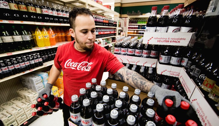 Albert Delarosa stocks shelves with Coca-Cola products at the IGA supermarket in the Port Richmond neighborhood of Philadelphia.