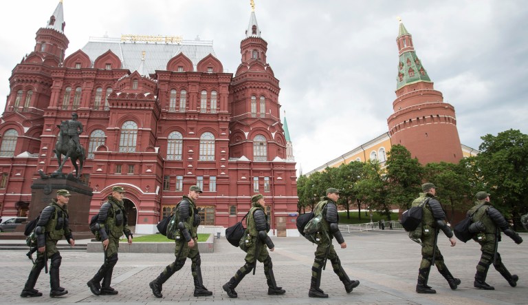 Interior Ministry soldiers walk past the Manezh Square with the Kremlin at the background in Moscow, Russia, Monday, June 12, 2017.