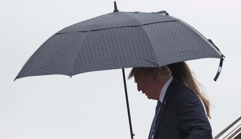 President Trump and first lady Melania Trump arrive in the rain.