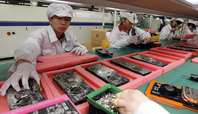 In this May 26, 2010, file photo, staff members work on the production line at the Foxconn complex in the southern Chinese city of Shenzhen, Southern city in China.