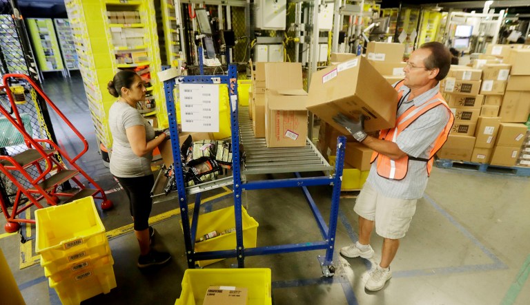 Workers handle boxes inside the Amazon Fulfillment center in Robbinsville Township, N.J.