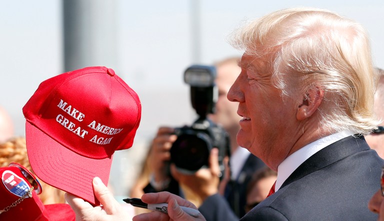 President Trump hands a signed "Make America Great Again" hat back to a supporter in Reno, Nev. 