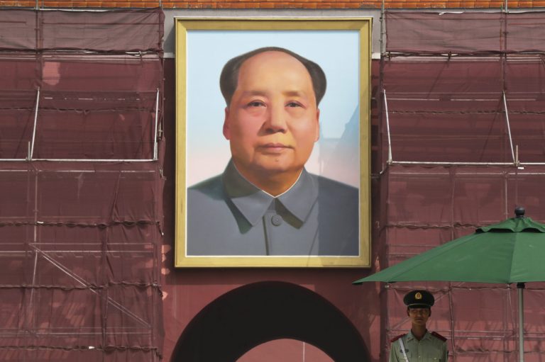 A Chinese paramilitary policeman stands watch against the portrait of the late Chinese leader Mao Zedong on Tiananmen Gate in Beijing.