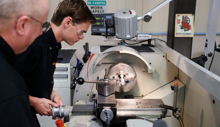 Apprentice Ryan Buzzy, 18, center, works with Skip Johnson, left, a trainer in STIHL's apprenticeship program, in their training area at the Stihl manufacturing facility, Thursday, May 25, 2017 in Virginia Beach.