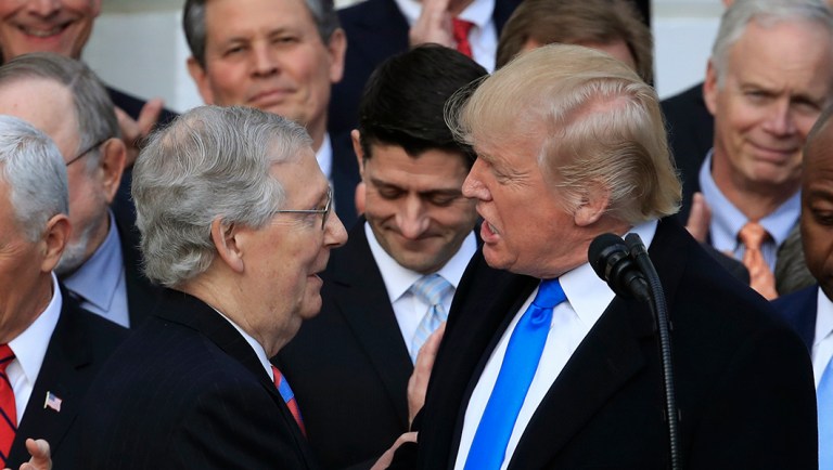 President Donald Trump, shakes hands with Senate Majority Leader Mitch McConnell of Ky., during a tax bill passage event on the South Lawn at the White House in Washington, Wednesday, Dec. 20, 2017. 
