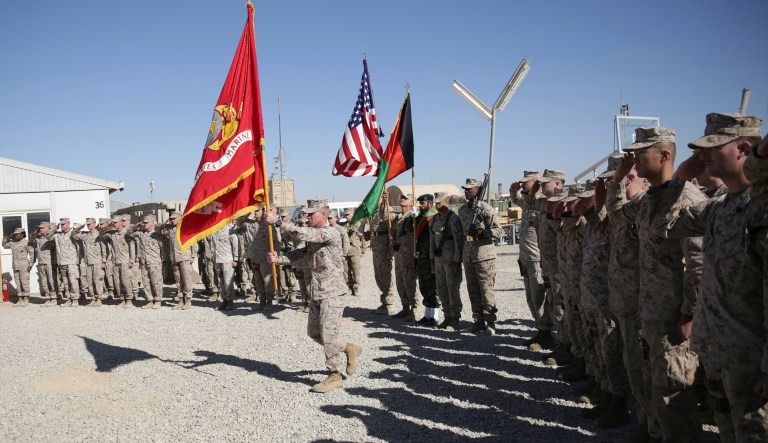 A U.S. Marine holds a marine's flag during the change of command ceremony at Task Force Southwest military field in Shorab military camp of Helmand province, Afghanistan, Monday, Jan. 15, 2018.