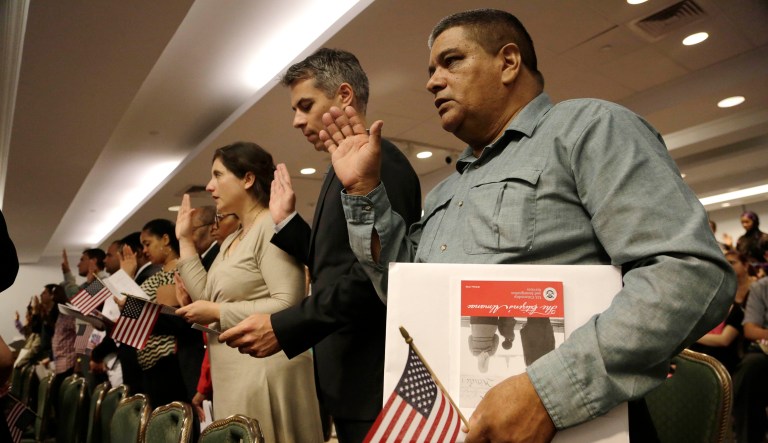 In this July 9, 2014 file photo New United States citizens recite the Oath of Allegiance while participating in a naturalization ceremony, in New York. 