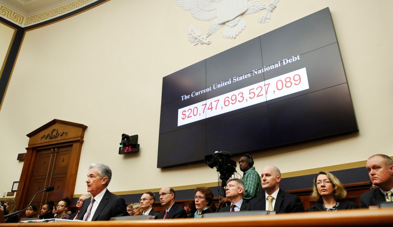 The national debt is shown behind Federal Reserve Chairman Jerome Powell during a hearing in Washington.