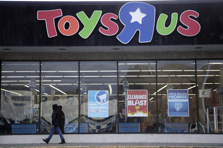 File- This Jan. 24, 2018, file photo shows a person walking near the entrance to a Toys R Us store, in Wayne, N.J.  Toys R Us's management has told its employees that it will sell or close all of its U.S. stores. That's according to a toy industry analyst who spoke to several employees who were on the call Wednesday, March 14, 2018. Jim Silver, a toy industry expert, says Toys R Us's CEO told employees the plan is to liquidate all of its U.S. stores and after that, it could do a deal with its Canadian operation to run some of its U.S. stores. The company declined to comment.
