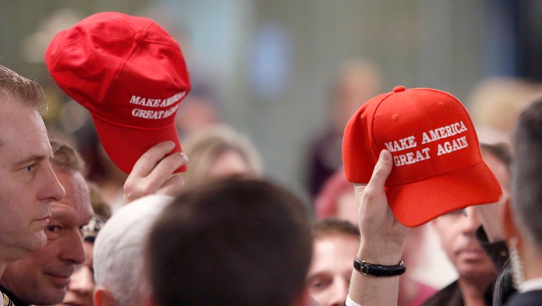 Members in the audience hold up "Make America Great Again" hats at the conclusion of a speech by Vice President Mike Pence at the America First Policies, "Tax Cuts to Put America First" event Thursday, March 22, 2018, in Manchester, N.H. 