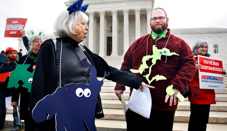 Helenmary Ball, left, of Calvert County, Md., as "Maryland District 5," points toward the separated area of Maryland District 3, being represented by Bobby Bartlett, right, as nonpartisan groups against gerrymandering protest in front of the Supreme Court, Wednesday, March 28, 2018, in Washington where the court will hear arguments on a gerrymandering case. The Supreme Court is taking up its second big partisan redistricting case of the term amid signs the justices could place limits on drawing maps for political gain.