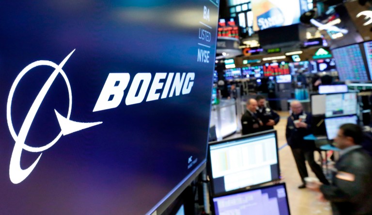 The logo for Boeing appears above the post where it trades on the floor of the New York Stock Exchange.