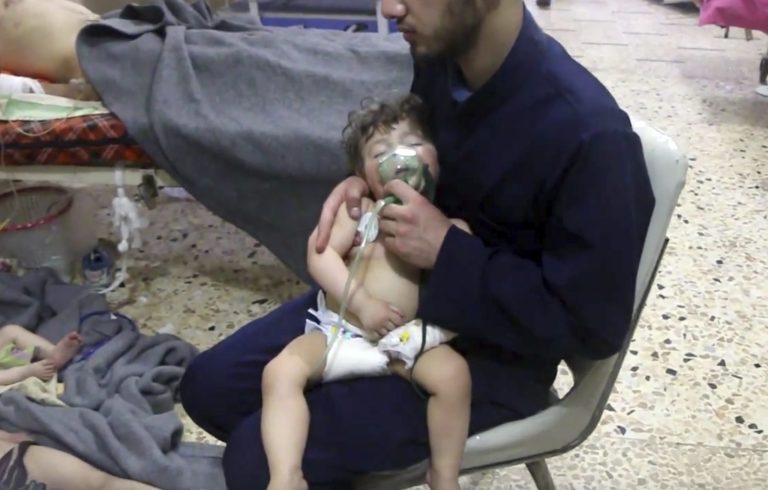 This image made from video released by the Syrian Civil Defense White Helmets, which has been authenticated based on its contents and other AP reporting, shows a medical worker giving toddlers oxygen through respirators following an alleged poison gas attack in the opposition-held town of Douma, in eastern Ghouta, near Damascus, Syria, Sunday, April 8, 2018. Syrian opposition activists and rescuers said Sunday that a poison gas attack on a rebel-held town near the capital. The Syrian government denied the allegations, which could not be independently verified.