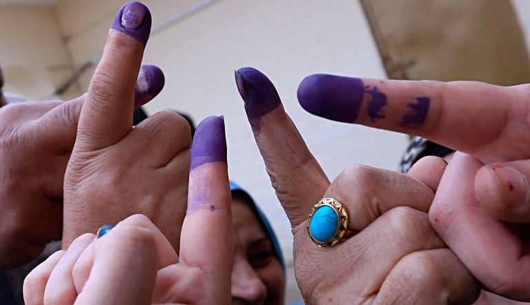Iraqis voters show their his ink-stained fingers after casting their votes inside a polling station in the country's parliamentary elections in Ramadi, Iraq, Saturday, May 12, 2018. 