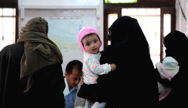 A woman holds her daughter after she received a diphtheria shot during a vaccination campaign, in Sanaa, Yemen, on May 13.