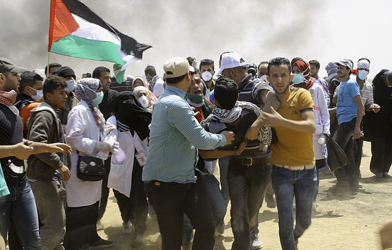 Palestinian protesters evacuate a wounded youth near the Israeli border fence, east of Khan Younis, in the Gaza Strip, Monday, May 14, 2018. Thousands of Palestinians are protesting near Gaza's border with Israel, as Israel prepared for the festive inauguration of a new U.S. Embassy in contested Jerusalem.