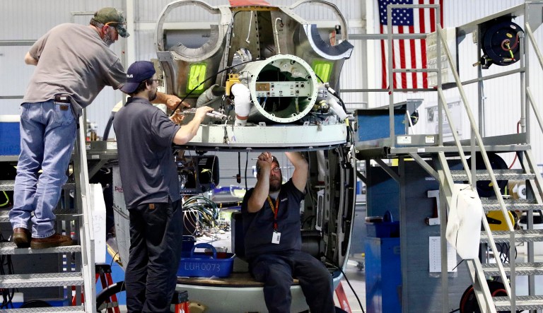 In this May 4, 2018 photo, technicians works on the wiring of a twin-engine Lakota helicopter, at the Airbus Helicopters, Inc., manufacturing facility in Columbus, Miss. U.S. factories cranked out more appliances, computers and aircraft last month, lifting manufacturing production for only the second time in five months. The Federal Reserve said Wednesday, May 16, that factory output rose 0.5 percent in April after a flat reading in March. 