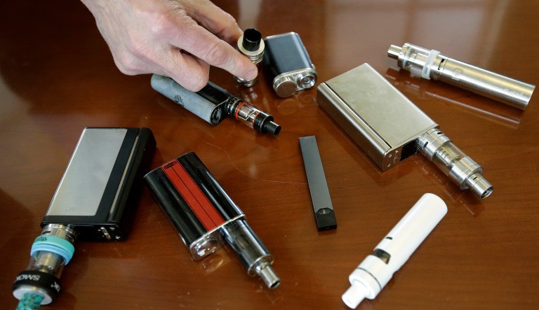 Vaping devices are laid out on a table.