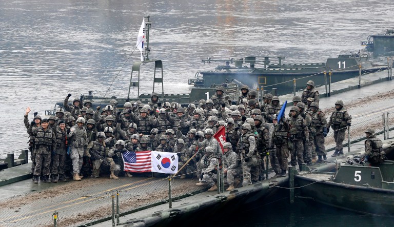 In this Dec. 10, 2015 file photo, U.S. and South Korean army soldiers pose on a floating bridge on the Hantan river after a river crossing operation, part of an annual joint military exercise between South Korea and the U.S. against a possible attack from North Korea, in Yeoncheon, South Korea.