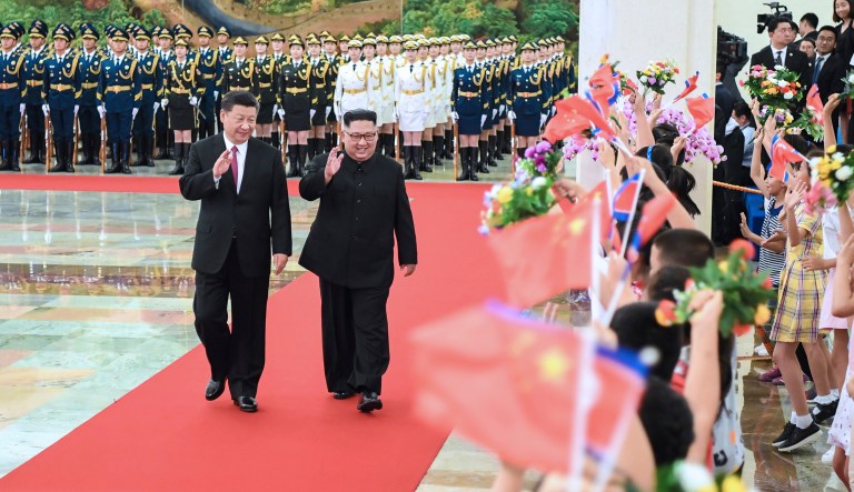 In this photo provided by China's Xinhua News Agency,  Chinese President Xi Jinping, left, North Korean leader Kim Jong Un, right, walk together during a welcoming ceremony for Kim at the Great Hall of the People in Beijing, Tuesday, June 19, 2018. President Xi told North Korean leader Kim on Tuesday he hopes Pyongyang and Washington can fully implement the outcome of last week's nuclear summit at which Kim pledged to work toward denuclearization in exchange for U.S. security guarantees.