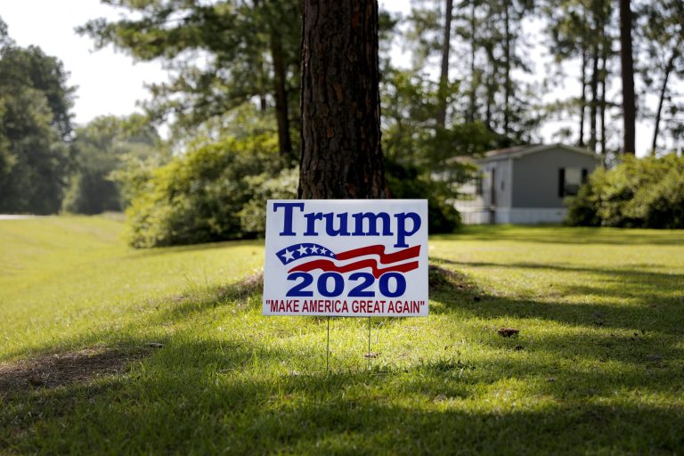 A 2020 presidential campaign sign supporting President Trump sits on a front lawn. 