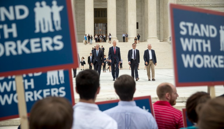 From left, Liberty Justice Center's Director of Litigation Jacob Huebert, Illinois Gov. Bruce Rauner, Liberty Justice Center founder and chairman John Tillman, and plaintiff Mark Janus walk out of the the Supreme Court after the court rules in a setback for organized labor that states can't force government workers to pay union fees in Washington, Wednesday, June 27, 2018.
