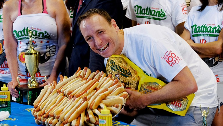 Ten-time and defending Nathan's Famous Men's Champion Joey Chestnut poses with 72 hot dogs during Nathan's Famous International Fourth of July Hot Dog Eating Contest in New York.