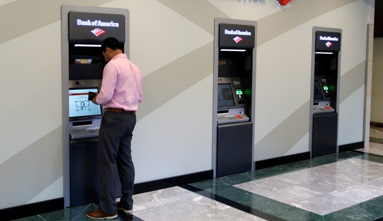 In this July 9, 2018, photo, a customer makes a transaction at a Bank of America ATM at the company's headquarters in Charlotte, N.C.