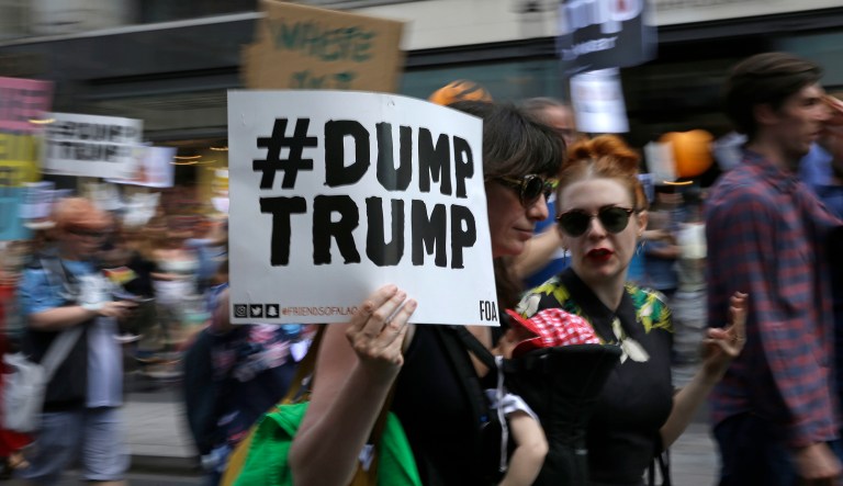 Protesters at a Women's March hold banners on July 13, 2018.