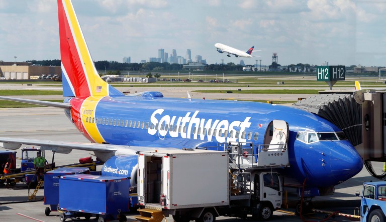 In this Tuesday, July 17, 2018, photograph, ramp workers prepare a Southwest Airlines Boeing 737 for departure to Denver from Minneapolis International Airport in Minneapolis.