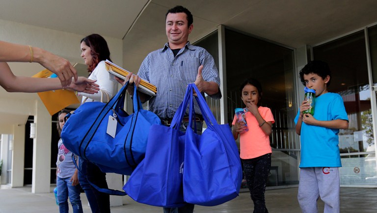 Immigrants from Honduras, Gerarado Reconco Lara, center, with his children Maria, 6, and Gerardo, 8, leave a Catholic Charities facility.