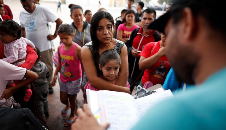 A woman from the Mexican state of Michoacan who did not give her name stands with her daughter as names are read off a list of people who will cross into the United States to begin the process of applying for asylum Thursday, July 26, 2018, near the San Ysidro port of entry in Tijuana, Mexico. As the Trump administration faced a court-imposed deadline Thursday to reunite thousands of children and parents who were forcibly separated at the U.S.-Mexico border, asylum seekers continue to arrive to cities like Tijuana, hoping to plead their cases with U.S. authorities.