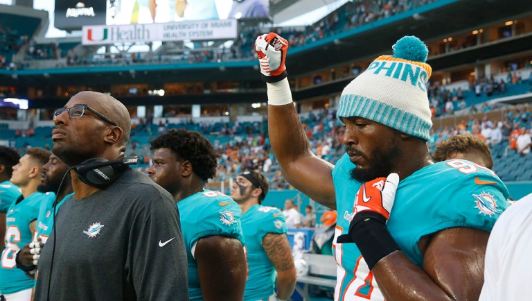 Miami Dolphins defensive end Robert Quinn (94) raises his right fist during the singing of the National Anthem.