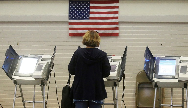 A person casts her ballot during an election.