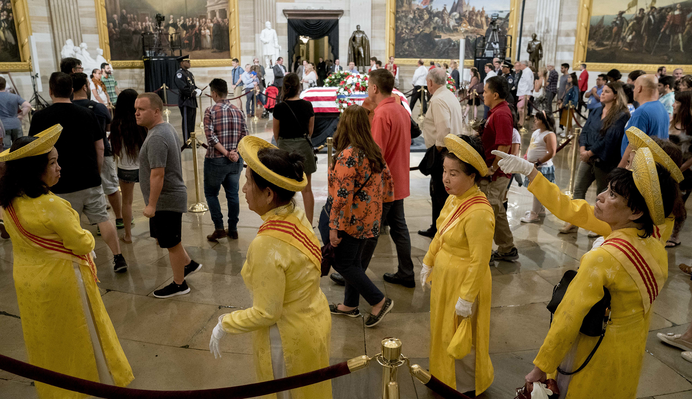 A group of South Vietnamese women in traditional dresses pay their respects to Sen. John McCain, R-Ariz., as he lies in state in the Rotunda of the U.S. Capitol, Friday, Aug. 31, 2018, in Washington.