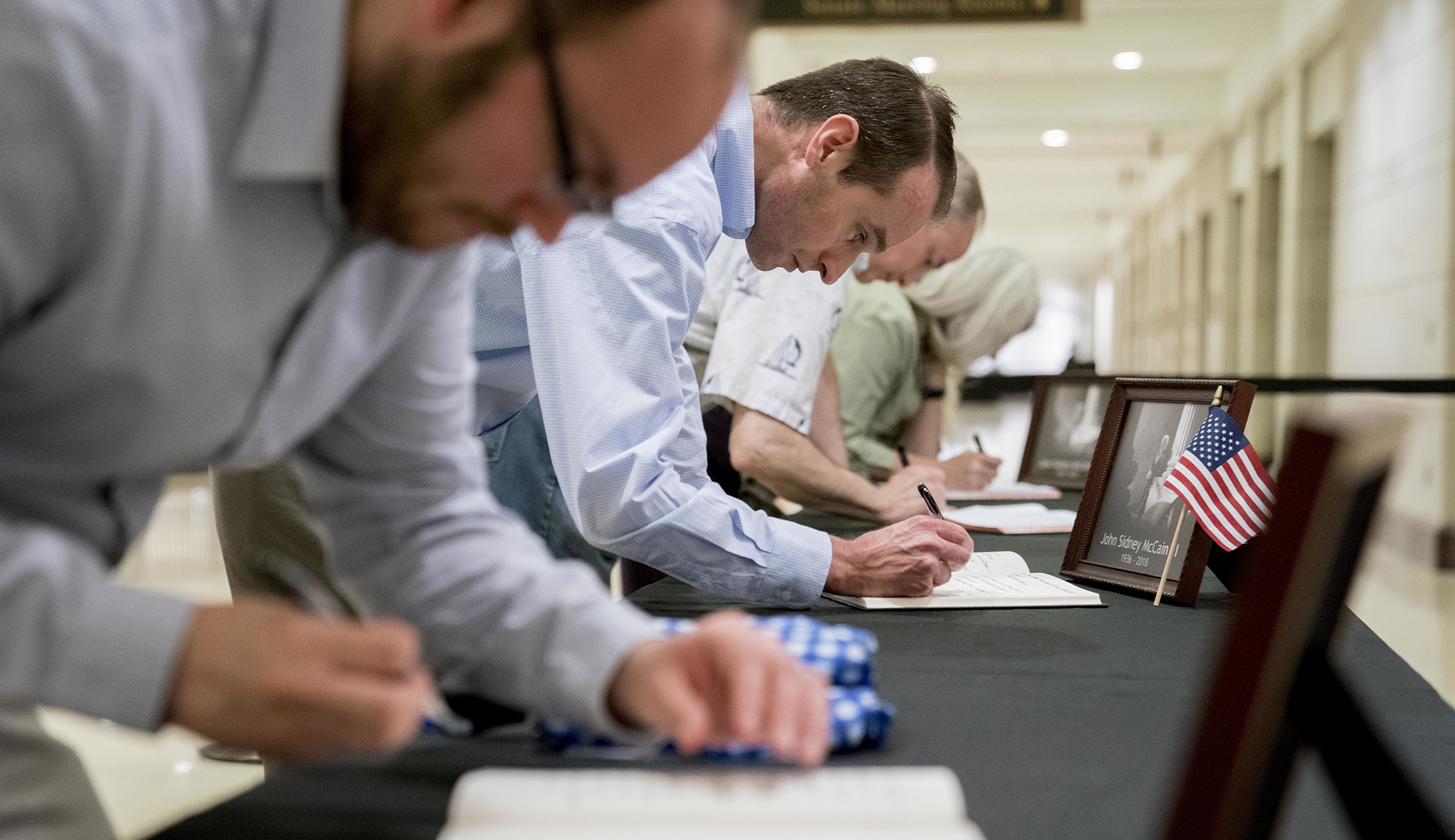 Visitors sign condolence books in the Capitol Visitors Center as Sen. John McCain, R-Ariz., lies in state in the Rotunda of the U.S. Capitol, Friday, Aug. 31, 2018, in Washington.
