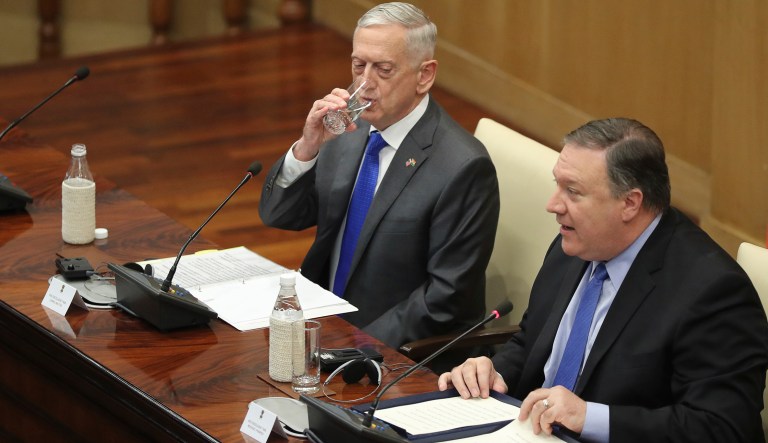 U.S. Defense Secretary James Mattis, left, drinks water as U.S. Secretary of State Mike Pompeo, makes his statement after the so called "2+2" meeting in New Delhi, India, Thursday, Sept. 6, 2018. Pompeo and Mattis held long-delayed talks Thursday with top Indian officials, looking to shore up the alliance with one of Washington's top regional partners.